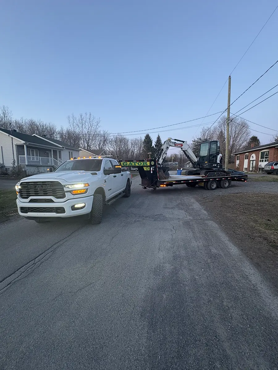 La camionnette RAM de l'Entreprise SME attelée au fardier, la mini-pelle Bobcat chargée, prête à partir en fin de journée