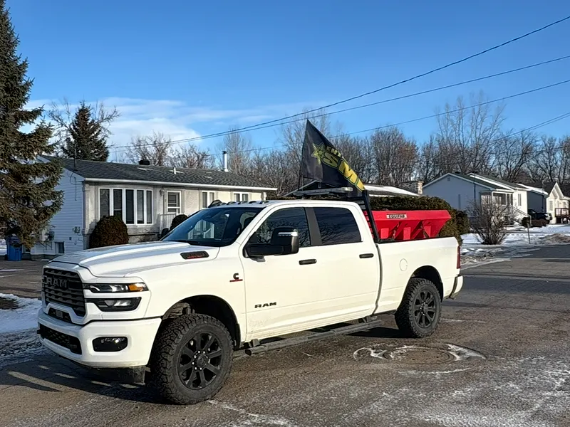 Camionnette RAM de l'Entreprise SME, épandeur d'abrasif rouge dans la boîte et drapeau SME, un jour d'hiver
