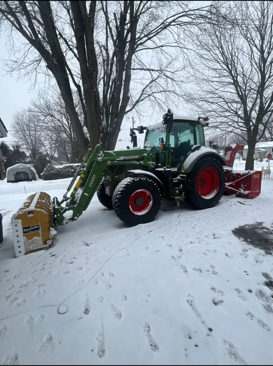 Tracteur Fendt vert de l'Entreprise SME dans la neige, souffleuse à l'arrière et chargeur à l'avant